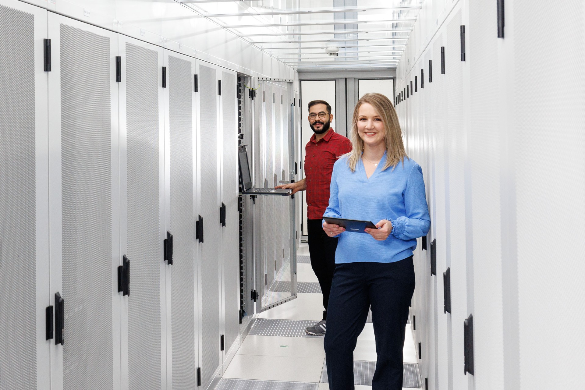 Ein Mann und eine Frau in einem Servergang im Rechenzentrum
